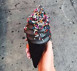 A black ice cream cone using charcoal for flavor - charcoal smoked ice cream